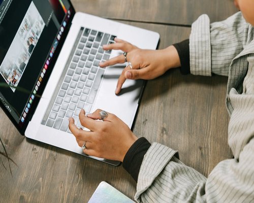 Close-up of hands typing on a laptop keyboard in a cozy home office setup